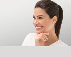 Mujer sonriendo tocándose el rostro 