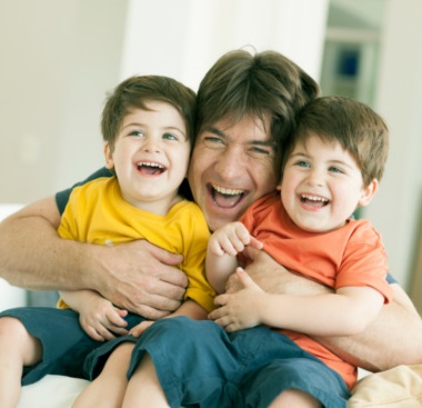 Padre e hijos abrazados sonriendo