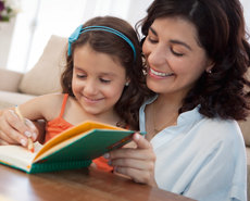 Madre e hija leyendo juntas, sonriendo