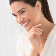 Mujer sonriendo con labios y ojos maquillados con productos de Natura Chronos
